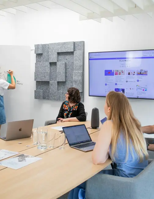 A team reviewing a social media feed on a meeting room screen